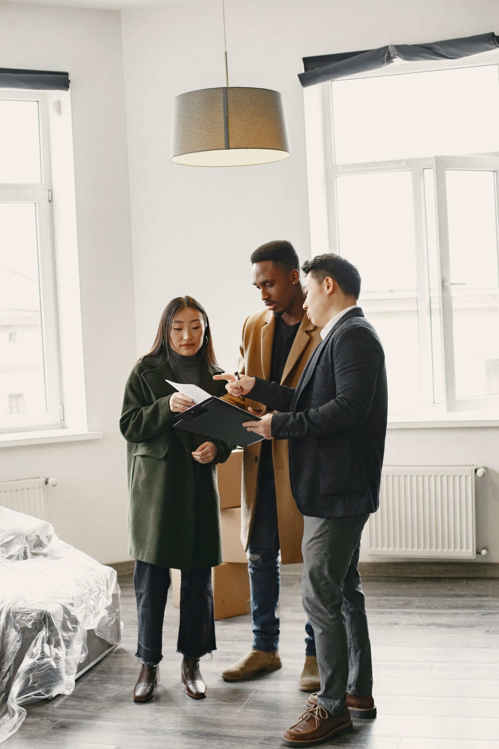 young couple buying new house asian woman african man signing documents new home scaled